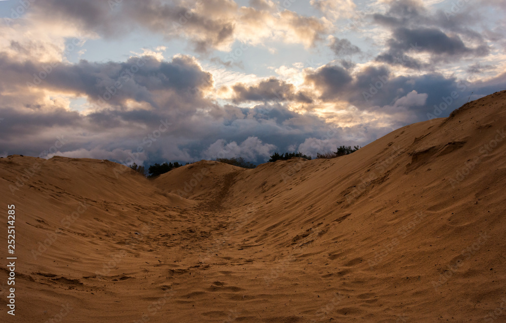 volumetric clouds on a background of sandy desert at sunset