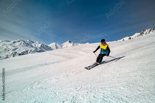 Male skier skiing on ski slope on a sunny winter day at the ski resort Gudauri in Georgia