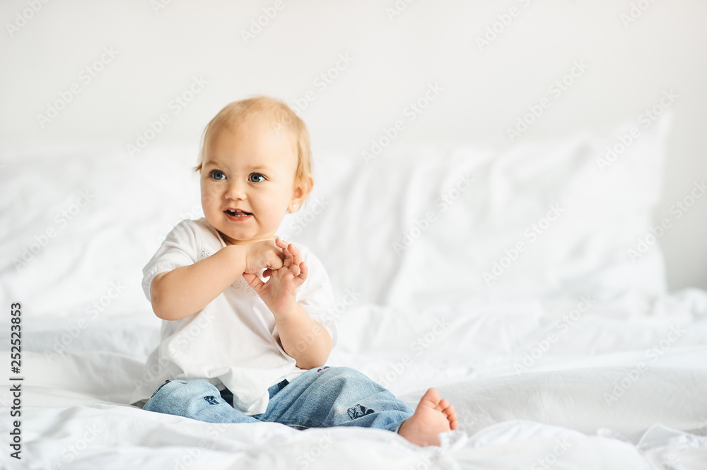 Happy kids playing in white bedroom. Little boy and girl, brother and sister play on the bed. Happy kids playing in white bedroom. Little boy and girl, brother and sister play on the bed.