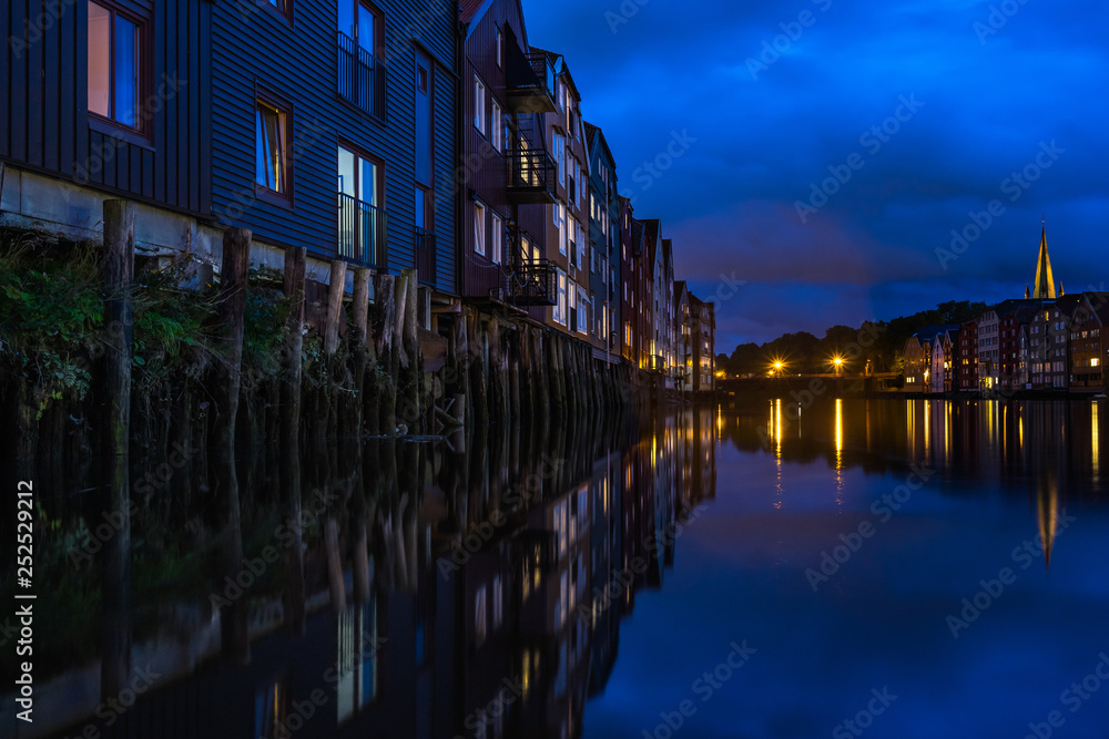 Detail of typical stilt houses on Nidelva River in Trondheim at night, Norway