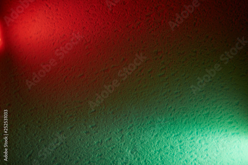Red and green lanterns on a textural background shine meeting each other
