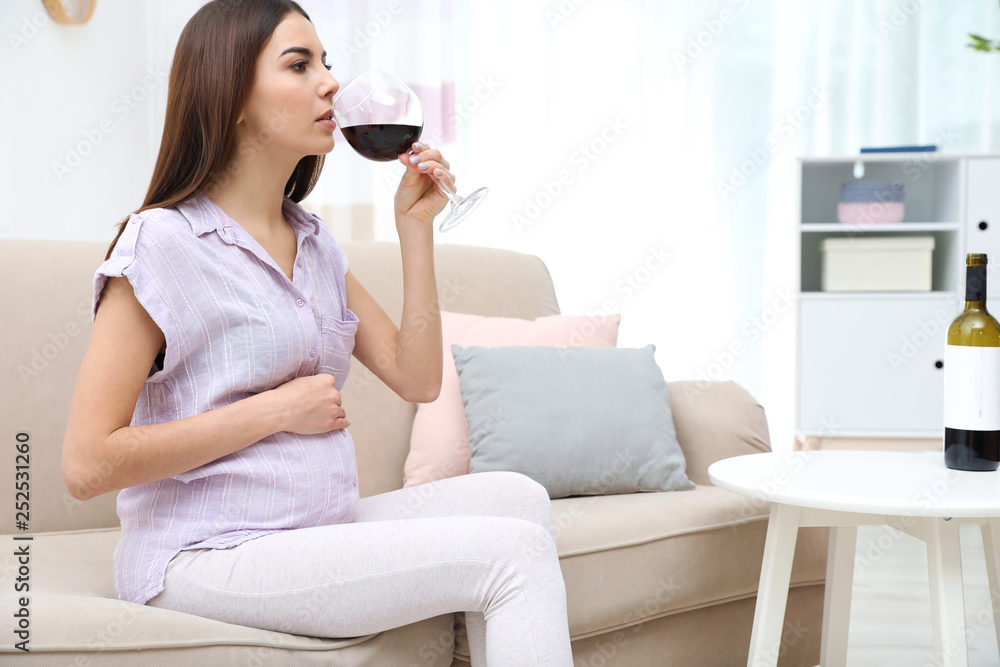 Future mother drinking wine from glass at home. Alcohol abuse during pregnancy Future mother drinking wine from glass at home. Alcohol abuse during pregnancy