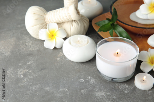 Beautiful spa composition with candles and flowers on grey background  space for text