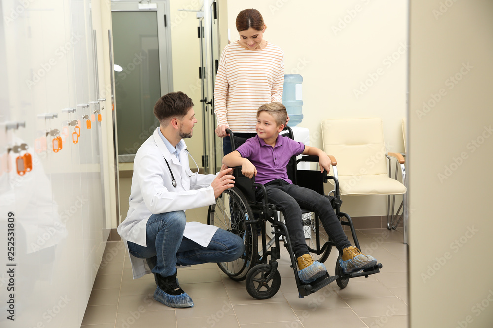 Doctor with woman and her child in wheelchair at hospital Doctor with woman and her child in wheelchair at hospital