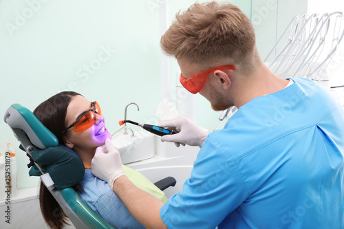 Professional dentist working with patient in modern clinic. Teeth whitening