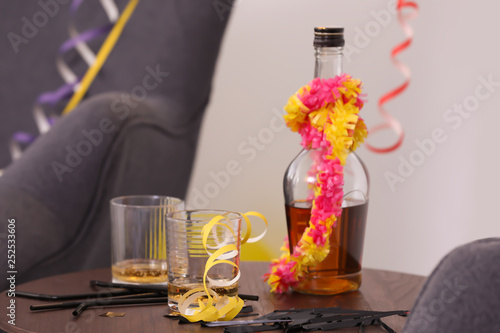 Messy table with glasses and bottle after party indoors