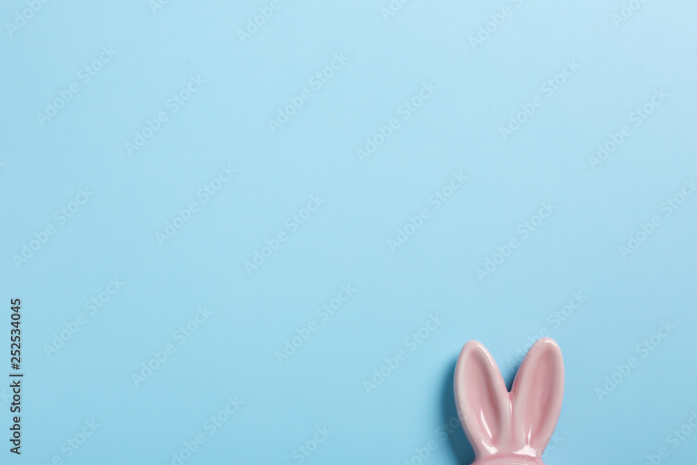 Easter bunny ears on color background, top view. Space for text