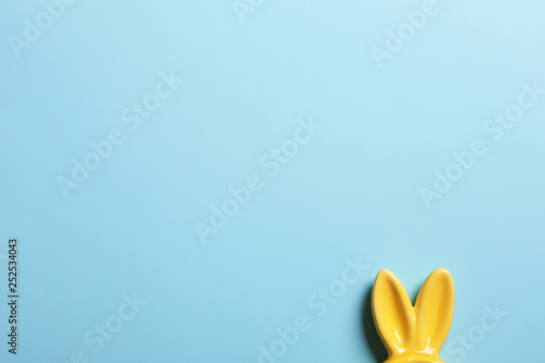 Easter bunny ears on color background, top view. Space for text