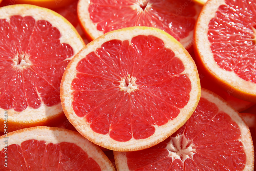 Many sliced fresh ripe grapefruits as background, closeup Many sliced fresh ripe grapefruits as background, closeup
