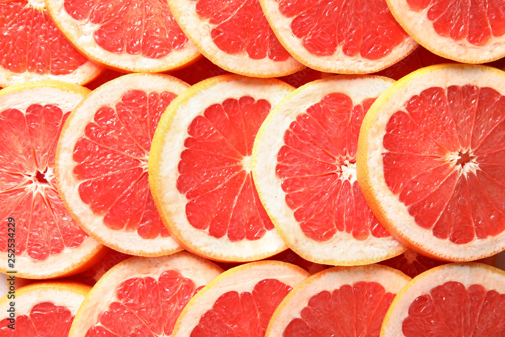 Many sliced fresh grapefruits as background, top view Many sliced fresh grapefruits as background, top view