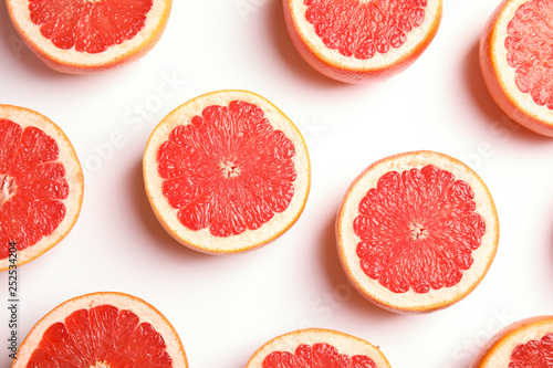 Fresh sliced ripe grapefruits on white background, top view