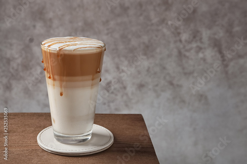 Bilde på lerret Glass of tasty caramel macchiato on table, Space for text