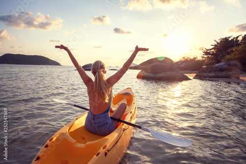 Girl on kayak sea at sunset, healthy lifestyle design. Sport, recreation Summer water sport, adventure outdoors. Tropical beach.
