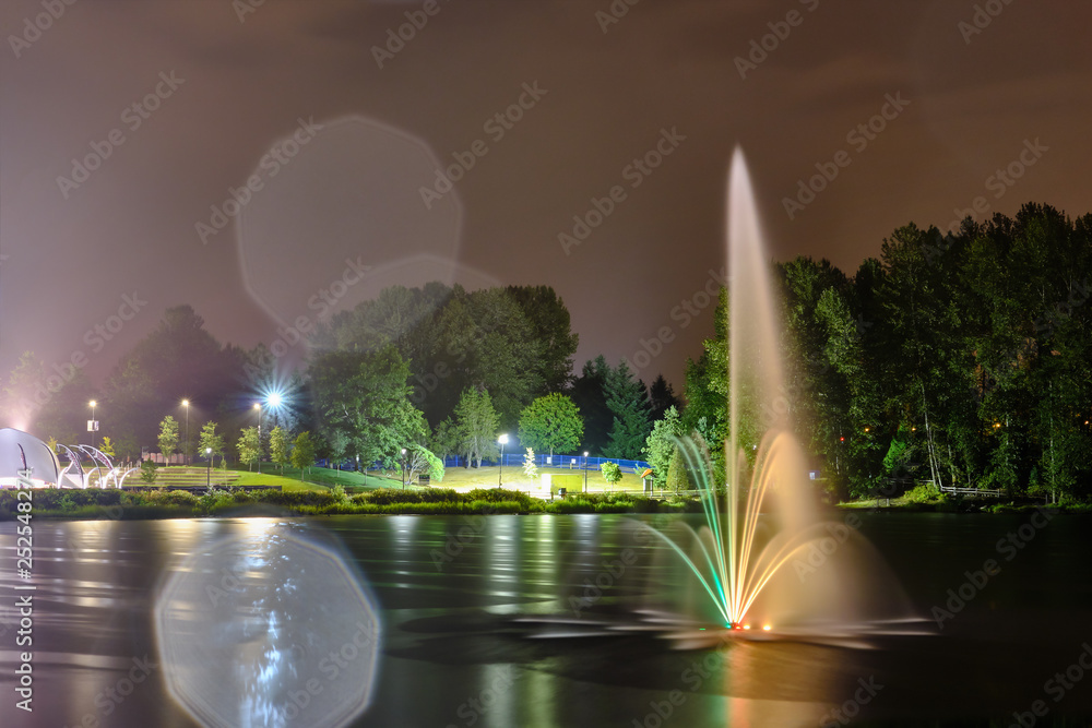 custom made wallpaper toronto digitalLafarge lake public park fountain in Coquitlam city, Great Vancouver, BC, Canada. Night view, multi color reflection