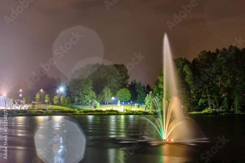 Wallpaper Mural Lafarge lake public park fountain in Coquitlam city, Great Vancouver, BC, Canada. Night view, multi color reflection Torontodigital.ca