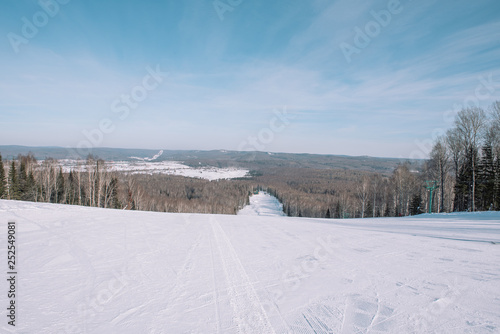Winter mountain view from above. View down from the mountain in winter. Winter landscape. Winter in Siberia.