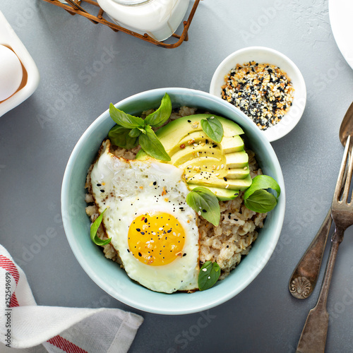 Fotografija Savory oatmeal with sunny side up egg and avocado for breakfast overhead
