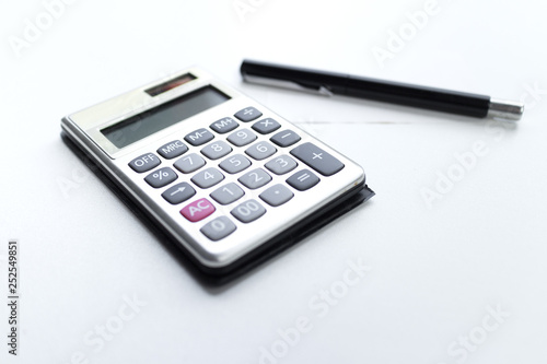 calculator with a pen and paper note with debt word isolated on white background © akkalak