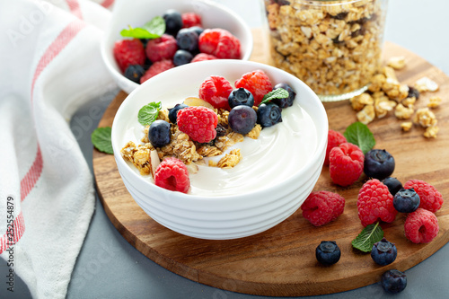 Plain yougurt with granola and berries on side, fresh, healthy and colorful breakfast