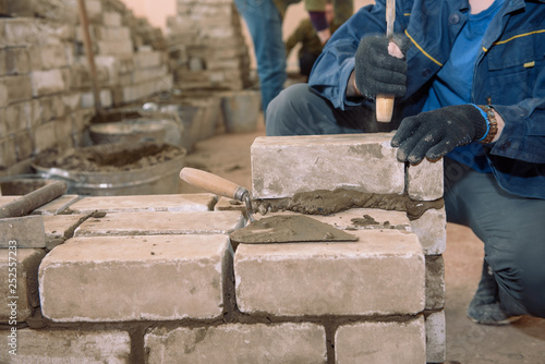 Build a wall of bricks. Students learn to lay bricks. Cement bond bricks. Spatula tamped cement. Profession builder.