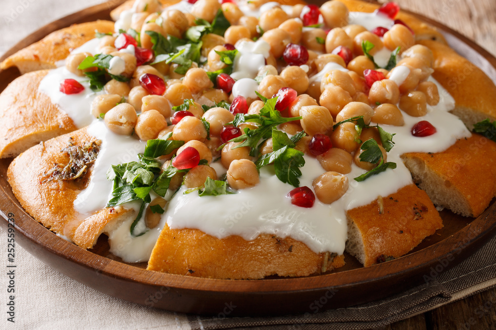authentic Lebanese Fatteh is made with yogurt, chickpeas and pita bread close-up on a plate. horizontal