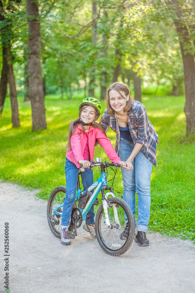 mother and daughter ride bikes in the forest