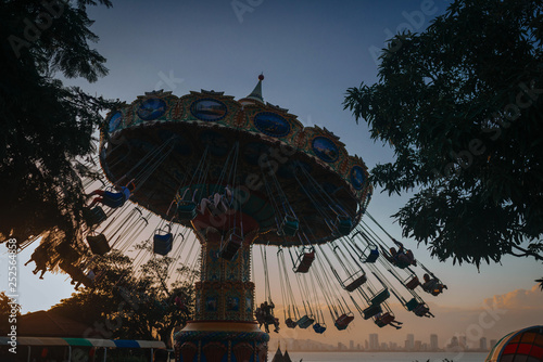  amusement park, carousels at sunset on the background of the sea