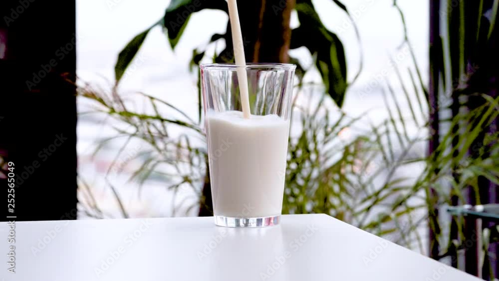 milk poured into glass, close-up. Glass of milk for breakfast milk poured into glass, close-up. Glass of milk for breakfast
