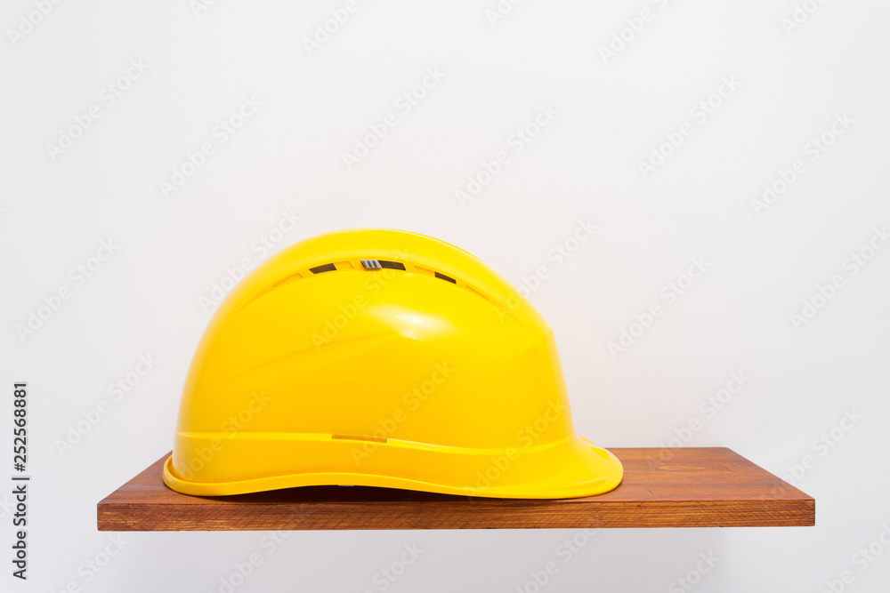 construction helmet on wooden shelf at white construction helmet on wooden shelf at white