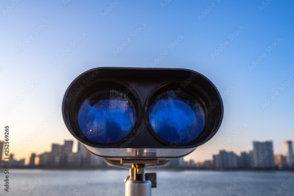 binoculars on background of blue sky and clouds