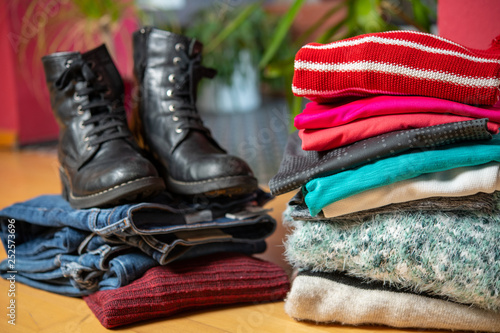 pile of second hand clothing and shoes with computer on floor
