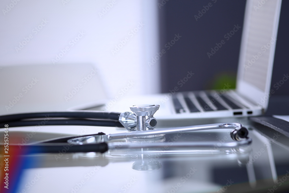 Stethoscope, prescription medical form lying on glass table with laptop computer. Medicine or pharmacy concept. Medical tools at doctor working table Stethoscope, prescription medical form lying on glass table with laptop computer. Medicine or pharmacy concept. Medical tools at doctor working table