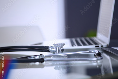 Stethoscope, prescription medical form lying on glass table with laptop computer. Medicine or pharmacy concept. Medical tools at doctor working table