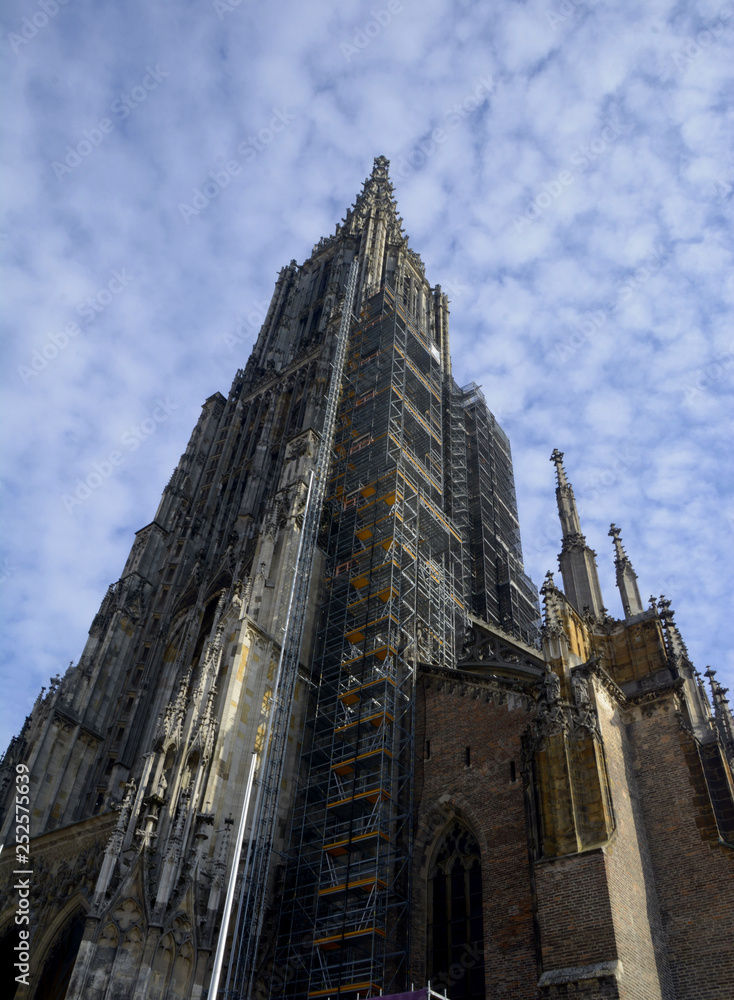 Ulm Minster exterior view from the west in front of blue sky covered with small clouds, tallest church of the world the minster of ulm abstract exterior view