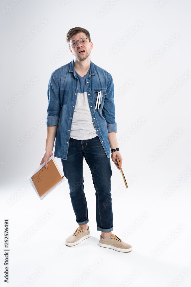 Happy young student standing full length with books and notes isolated on white background. Happy young student standing full length with books and notes isolated on white background.