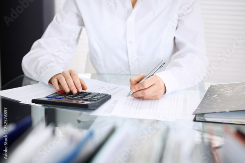 Unknown bookkeeper woman or financial inspector making report, calculating or checking balance, close-up. Business portrait. Audit or tax concepts
