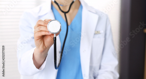Unknown doctor woman holds stethoscope head, close-up. Physician ready to examine and help patient. Helping and insurance in health care, best treatment and medicine concept