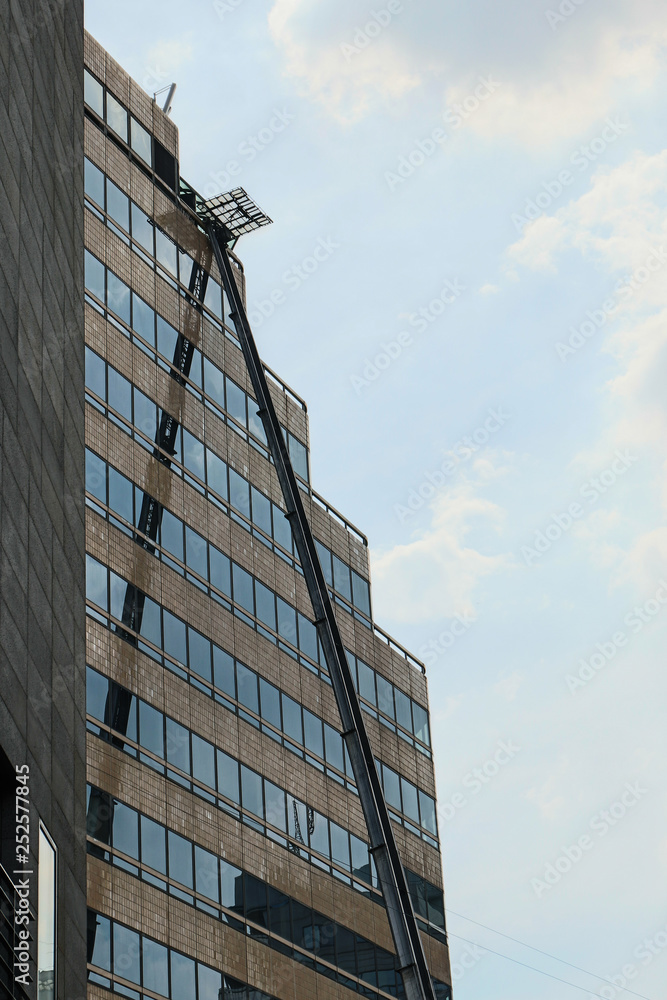 Extra long retractable ladder for high-rise work on high-rise bu