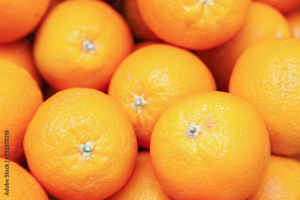 Many tasty ripe orange mandarins are piled on counter at the farmers market. New Year fruit concept, fresh squeezed vitamin juice, healthy foods Many tasty ripe orange mandarins are piled on counter at the farmers market. New Year fruit concept, fresh squeezed vitamin juice, healthy foods