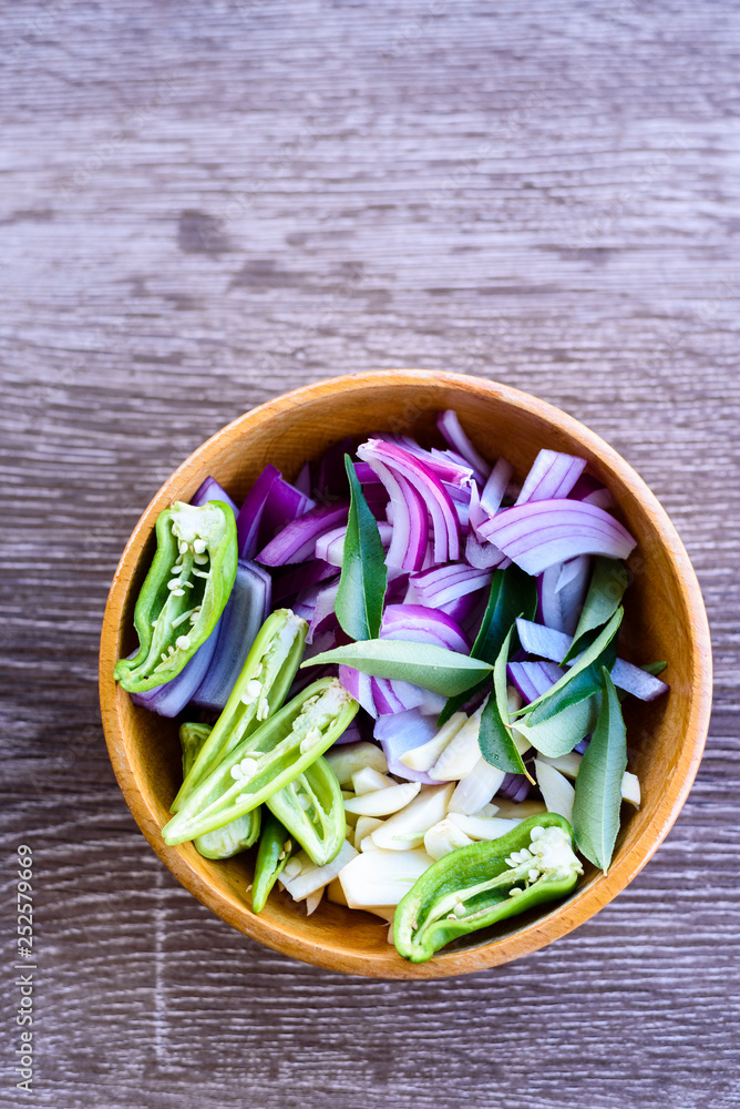 bowl of sliced onions, garlic, green chili and curry leaves bowl of sliced onions, garlic, green chili and curry leaves