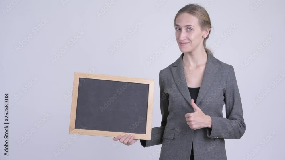 Happy young blonde businesswoman holding blackboard and giving thumbs up Happy young blonde businesswoman holding blackboard and giving thumbs up