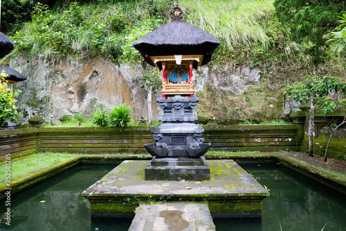 Bali, Indonesia, Ubud. Elephant cave Goa Gaja. On the territory of the temple complex Goa Gaja is an altar among the pond with carp. photo