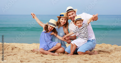 happy family father, mother and children on beach at sea