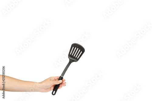 Hand with Black plastic kitchen spatula, kitchenware for cooking