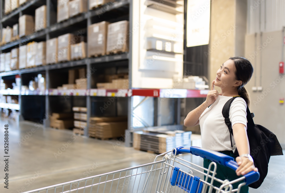 Woman use cart for shopping furniture in warehouse Woman use cart for shopping furniture in warehouse