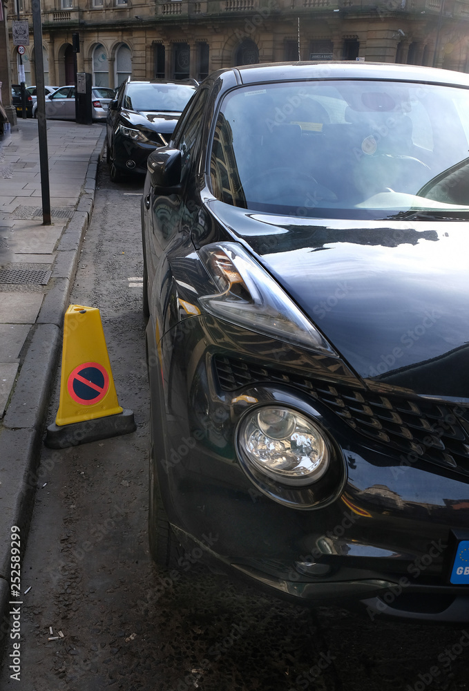 Car parked illegally at restricted sign.