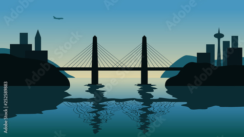Cable bridge over strait against sunset. Flying plane over the city on the background