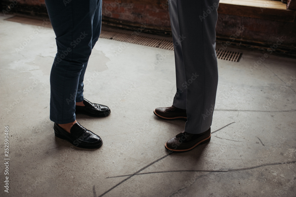 The two men communicate. Suit, shoes. Business meeting. A friend helps dress the groom. The two men communicate. Suit, shoes. Business meeting. A friend helps dress the groom.