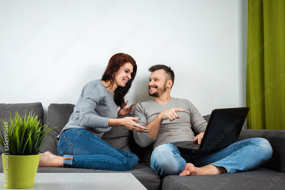 The girl and the guy have fun in two for the laptop. The concept of family relationships, watching movies together, sharing time. The girl and the guy have fun in two for the laptop. The concept of family relationships, watching movies together, sharing time.