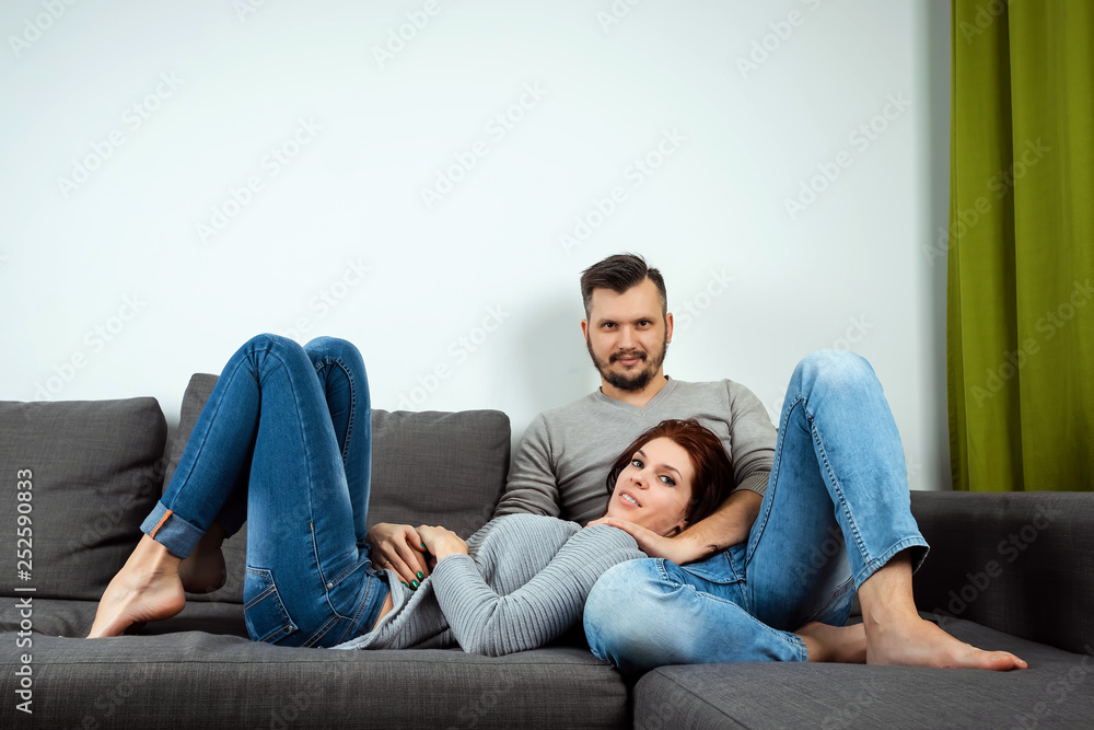 A loving couple lying on a bed at home, a lazy family resting on the weekend. Family relationships, love. A loving couple lying on a bed at home, a lazy family resting on the weekend. Family relationships, love.